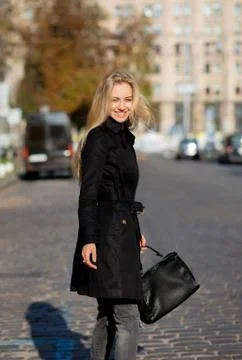 Sunny spring portrait of happy blonde woman enjoying warm weather, walking do Stock Photos