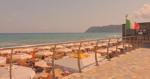 Sunny summer day at a crowded beach resort with rows of beach umbrellas, sun Stock Footage 341840657