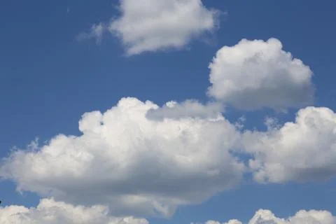 In sunny summer, huge clouds float on the blue sky. Stock Photos