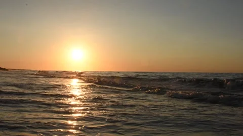 Sunny sunset on the beach with focus on ocean waves and golden water reflection Stock Footage 327085073