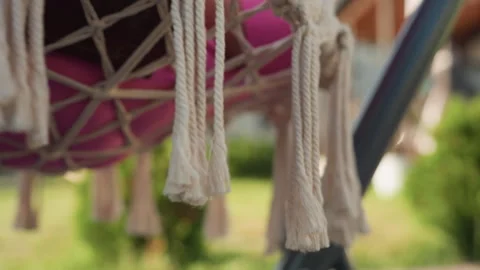 Sunny Tassels On Boho Swing, Soft Bokeh Background With Garden Shrubs, Close Stock Footage 329530313