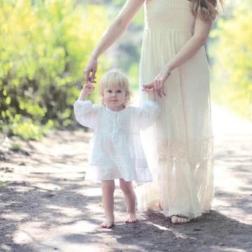 Sunny warm portrait mom and daughter walking in the forest summer day Stock Photos