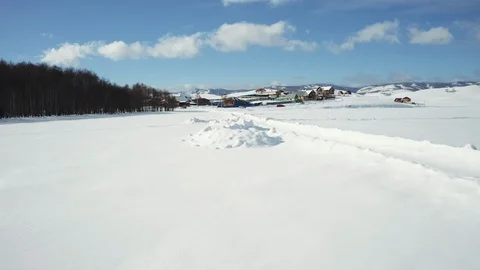 Sunny winter day, drone flight over the snowy road in village Stock Footage 103279161