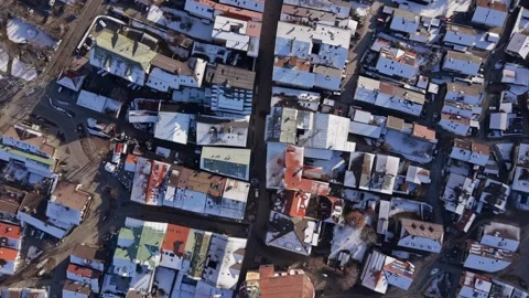 A sunny winter flight over the main street of Mittenwald. The baroque St Peter Stock Footage 329279912
