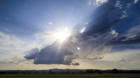 Sunrays behind a thundercloud at sunset Видео 90490886