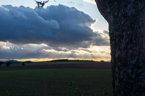 Sunrays breaking through dark clouds in the distance Stock Photos