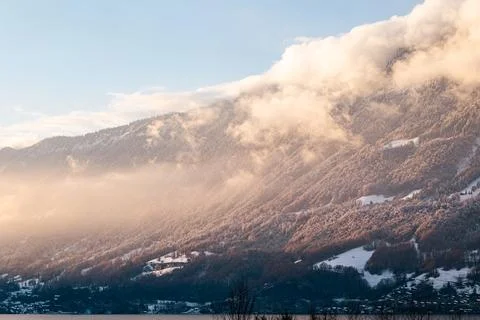 Sunrays hitting the side of a mountain with forest in Brienzersee Stock Photos