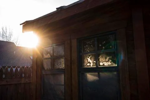 Sunrays illuminate a frost pattern on a window of a tool shed on a winter mor Foto stock