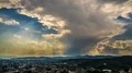 Sunrays penetrating clouds in heavenly sky above mountain resort city, timelapse 4k or 4k+ Resolution