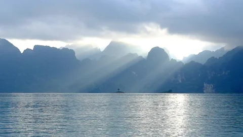 Sunrays through clouds over mountain and big lake landscape Stock Footage 100676685
