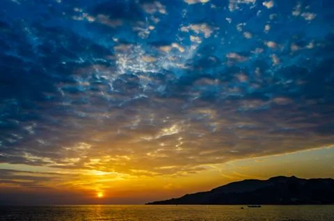 Sunrise accompanied by dramatic clouds Stock Photos