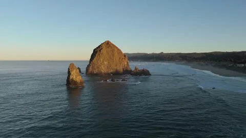 Sunrise Aerial Orbit of Haystack Rock Revealing Cannon Beach Town Stock Footage 300510124