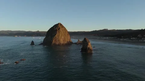 Sunrise Aerial Orbit of Haystack Rock with Cannon Beach Town in the Background Stock Footage 300510133