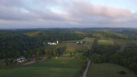 SUNRISE, AERIAL SHOT, PULL BACK FROM BEAUTIFUL WHITE FARMHOUSE IN MIDWEST Video stock 71208774