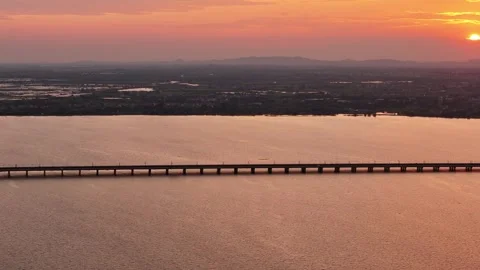 Sunrise aerial view of bridge over river with warm morning light in China Stock Footage 337759678