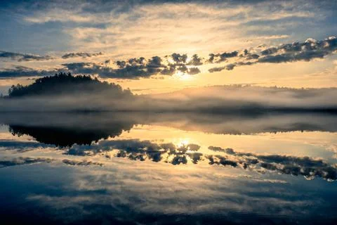 Sunrise and dramatic clouds by a lake Stock Photos
