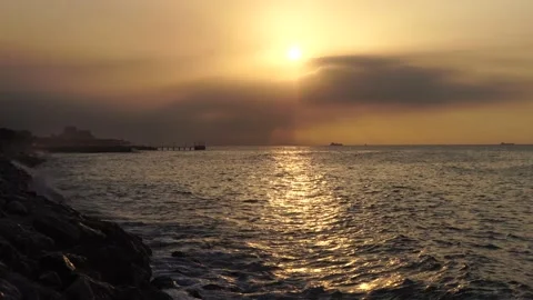 SUNRISE AND THE WAVES SHALLING TO THE COAST Stock Footage 238494845
