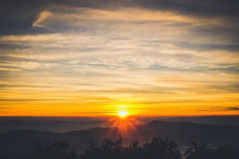 Sunrise backlit sky with cloud on the top of mountain Stock Photos