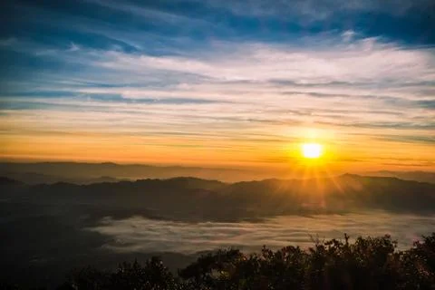 Sunrise backlit sky with cloud on the top of mountain Stock Photos