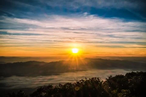 Sunrise backlit sky with cloud on the top of mountain Stock Photos