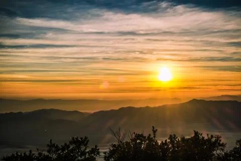 Sunrise backlit sky with cloud on the top of mountain Stock Photos