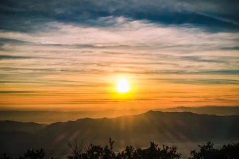 Sunrise backlit sky with cloud on the top of mountain Stock Photos
