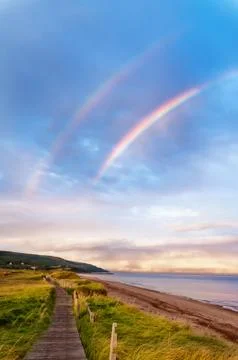 Sunrise at a beach with double rainbow 스톡 사진