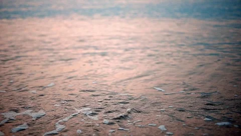 Sunrise on the beach - slow motion of foamy waves rolling towards the beach.  Stock Footage 256026874
