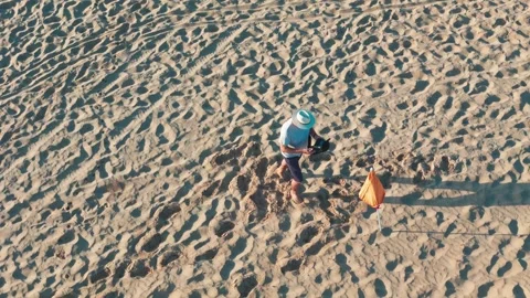 Sunrise beach walk: man in a white hat, light shirt, shorts, and flip-flops.. Stock Footage 283973519
