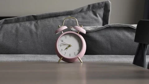 Sunrise in the bedroom. Rays of sun illuminate the alarm clock on the night.. Stock Footage 304695881