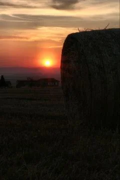 The sunrise behind the haystack in summer Stock Photos
