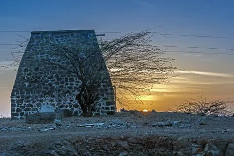 Sunrise behind an old stone structure in a small village in outskirts of city Stock Photos