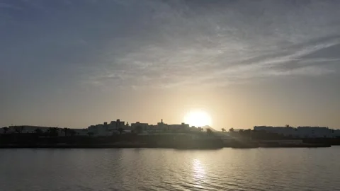 Sunrise Behind Resort Silhouette Across Calm Water in Lanzarote Video stock 344952553