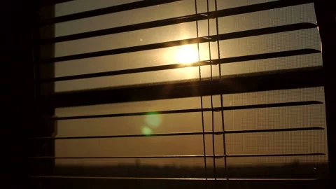 Sunrise behind the window blinds and mosquito net. Sun behind window blinds. Stockbeeldmateriaal 120509563
