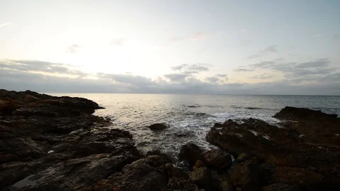Sunrise between rocks and the Oropesa Sea Stock Footage 116774475