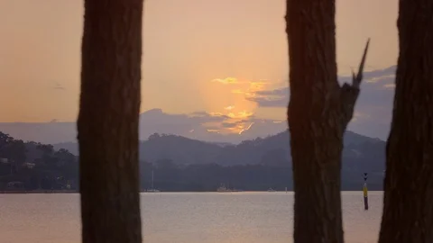 Sunrise breaking through cloud over water Stock Footage 111996756