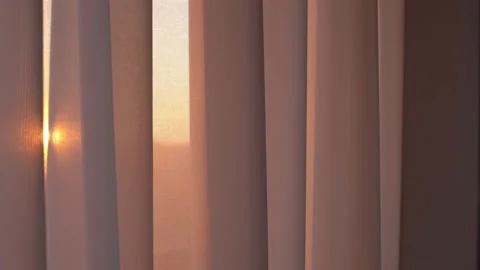 Sunrise breaks through the window through the tulle. The curtain barely sways in Vidéo 164856740
