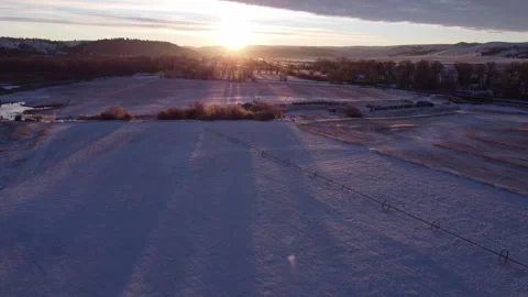 Sunrise casting shadows across winter Montana landscape fields Stock Footage 310569242