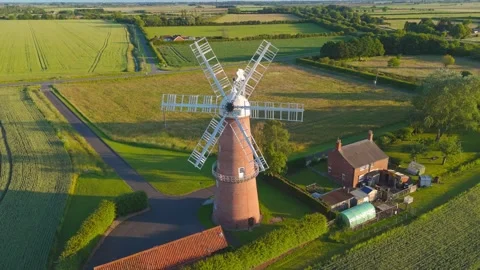 Sunrise casts golden light over historic windmill Видео 342611317