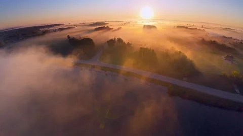 Sunrise casts long shadows across misty scenic landscape Stock Footage 300601978