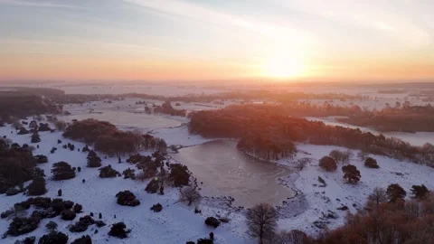 Sunrise Casts Warm Glow Over Icy Terrain Featuring Winding Paths And Distant Stock Footage 327051906