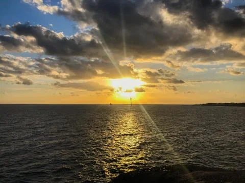 Sunrise from a cliff with moving clouds in a different direction forming a li Stock-Fotos