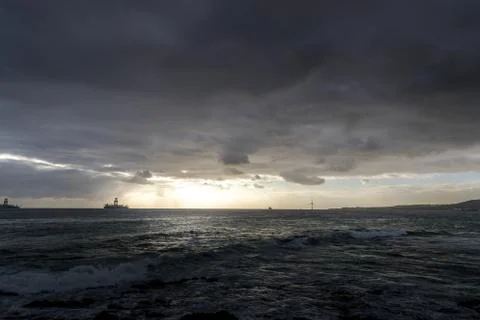 Sunrise from a cliff with moving clouds in a different direction forming a li Stock-Fotos