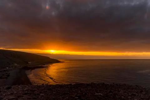 Sunrise from a cliff with moving clouds in a different direction forming a li Stock-Fotos