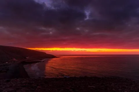 Sunrise from a cliff with moving clouds in a different direction forming a li Stock-Fotos
