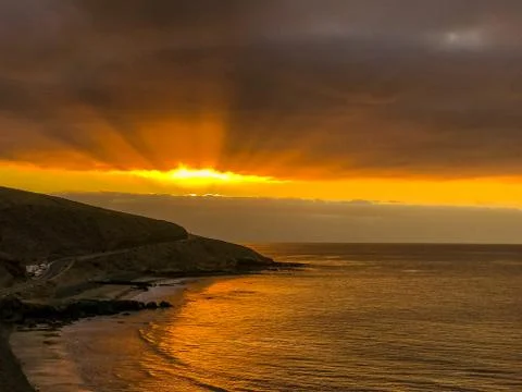 Sunrise from a cliff with moving clouds in a different direction forming a li Stock-Fotos