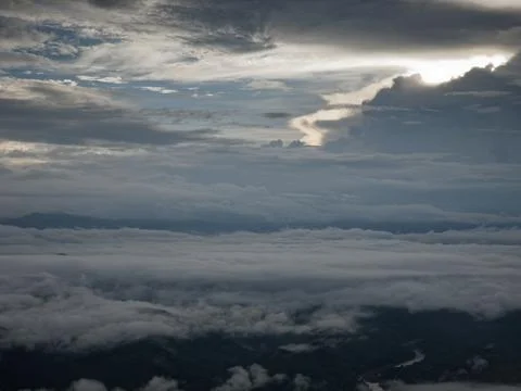 Sunrise cloud clusters in open air blue sky abrove the mountain Stock Photos