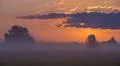 The sunrise with clouds and above foggy field and forest. early morning time Photo