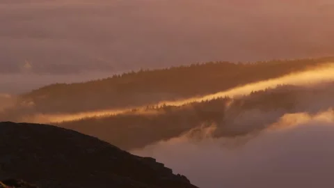 Sunrise clouds moving slowly over mountain trees in Snowdonia landscape Видео 168736689
