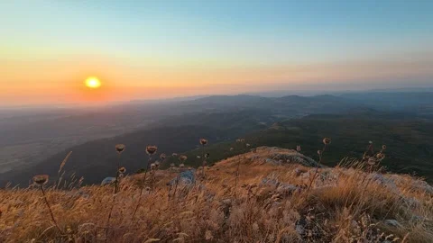 Sunrise dips over distant hills, casting golden light. Mount Rtanj Serbia Stock Footage 344685848